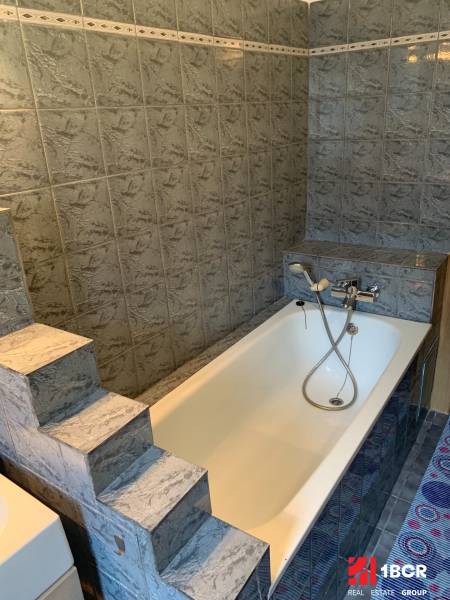 A bathroom with a cast iron bathtub and steps, typical for a 2-room apartment.