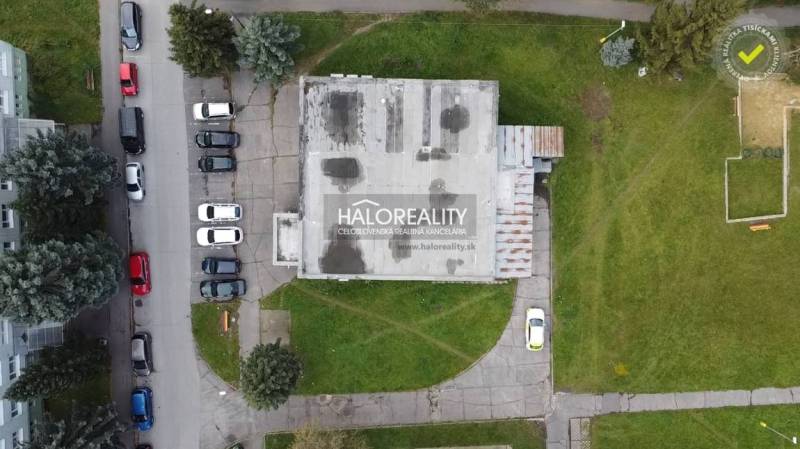 A top view of commercial premises in Rimavská Sobota, surrounded by greenery and parked cars.