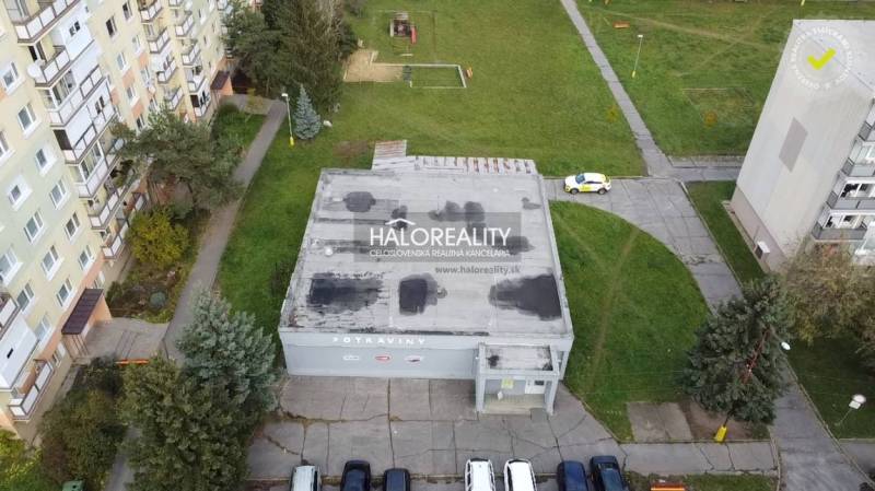 Commercial premises in Rimavská Sobota with a flat roof, surrounded by greenery and apartment buildings.