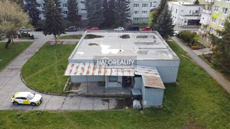 View of commercial premises in Rimavská Sobota with an adjacent park and a concrete roof.