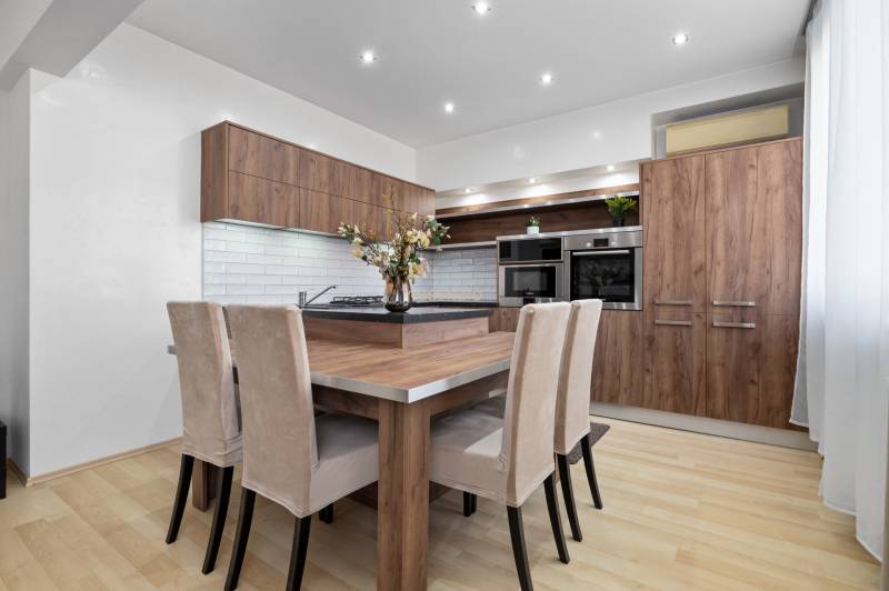 A kitchen in a 2-room apartment with wooden decor furniture and light walls.