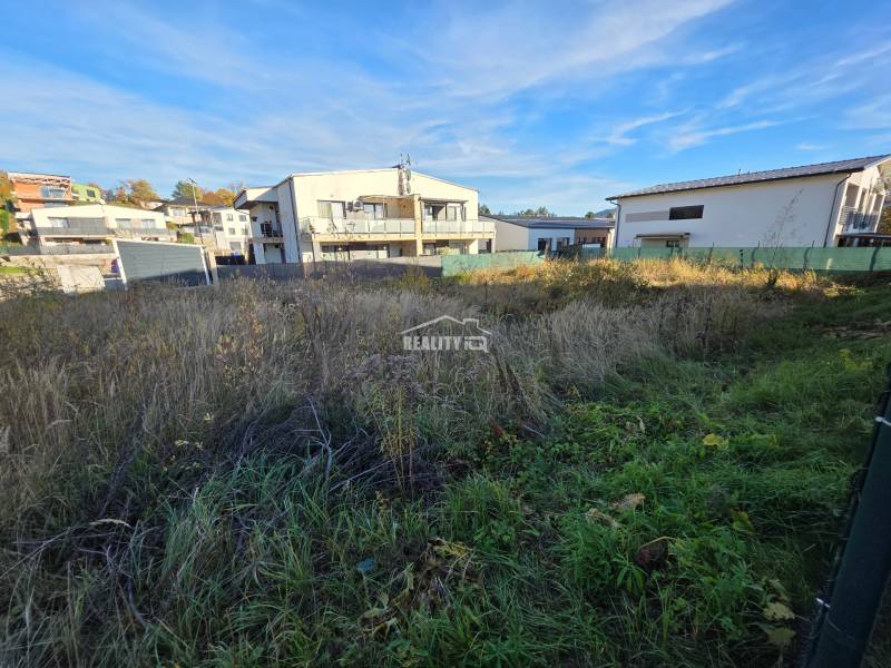 Plots - housing in Bytča with a view of the surrounding houses. Grass and greenery on the area.