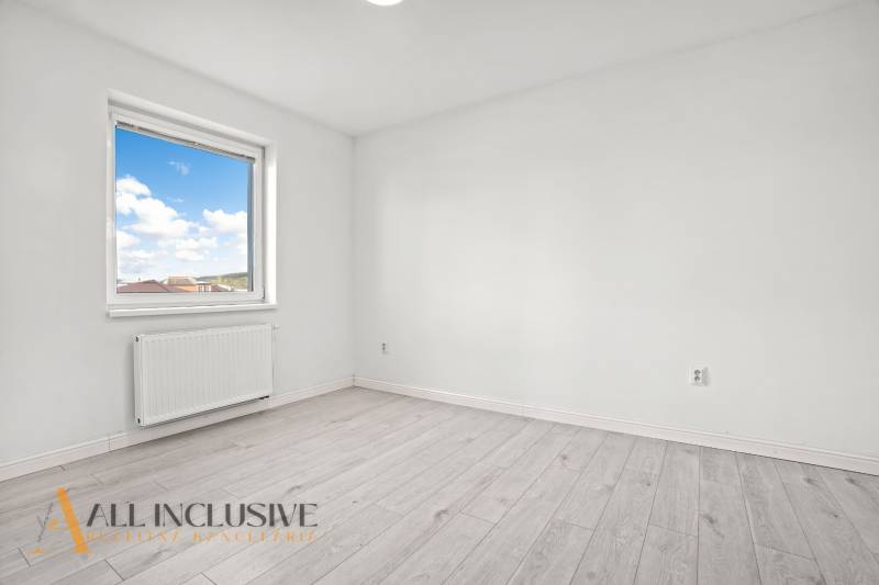 A room in a 2-room apartment with a window and a floor with a wooden decor.