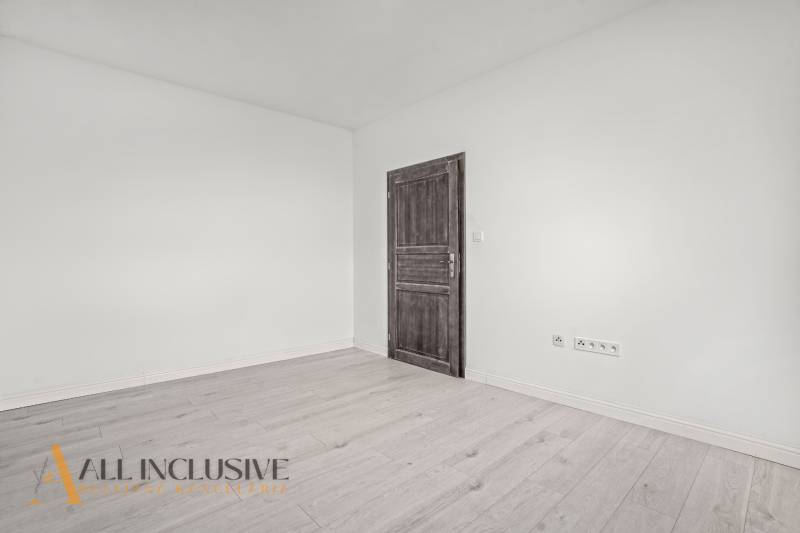 Interior of a 2-room apartment with white walls and a wooden decor floor.