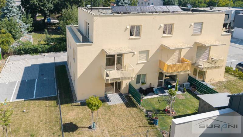 Yellow apartment building on Železničná Street in Bratislava-Vrakuňa with a garden and parking spaces.