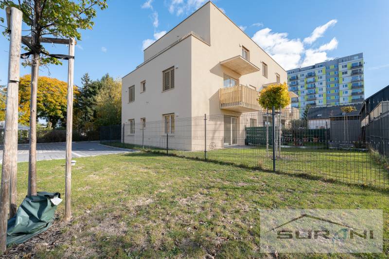 The exterior of the apartment building on Železničná Street in Vrakuňa with an adjacent garden.
