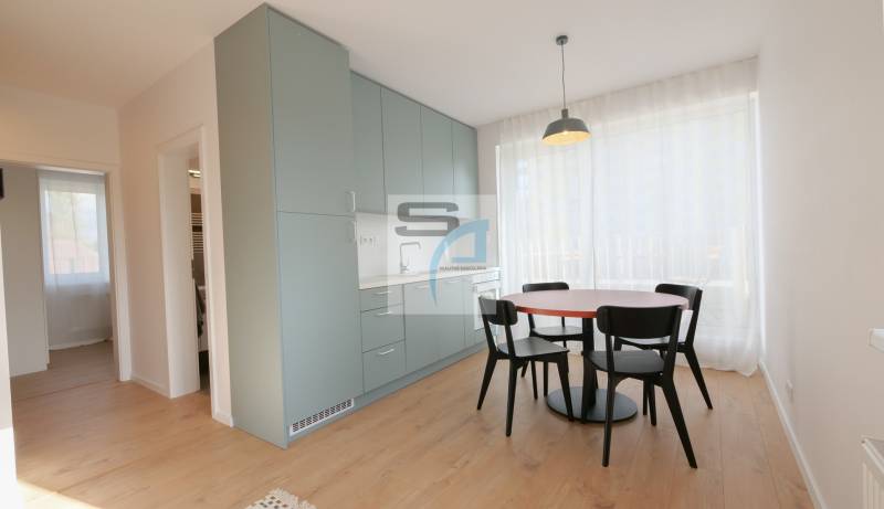 Dining area with a table and chairs, built-in cabinets, and a floor with a wood decor.