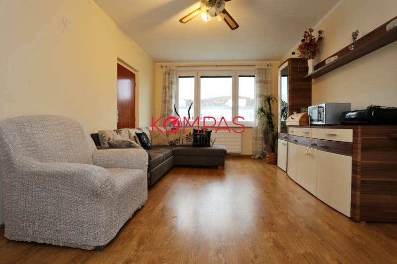 Living room with a sofa and cabinets, floor with wooden decor, 3-room apartment.
