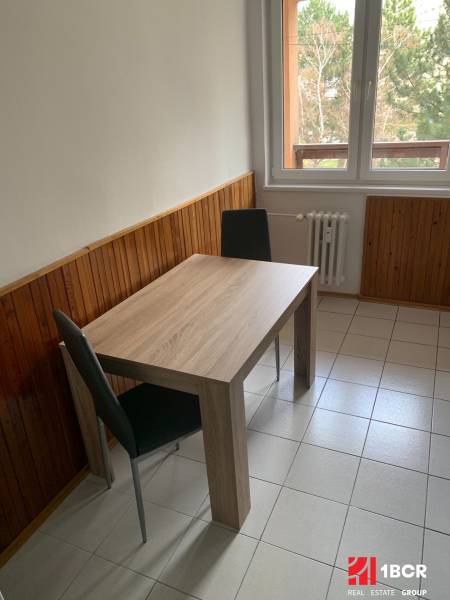 Dining area with a wooden decor table in a 2-room apartment.