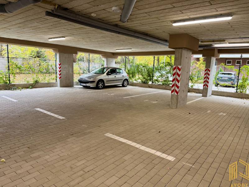 Spacious parking in garages on Sadova Street in Senica with a car and pillars.