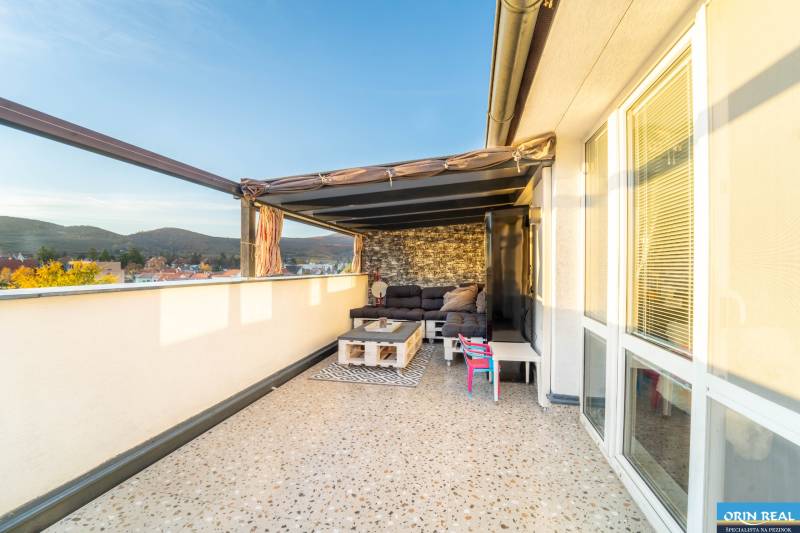 Terrace with seating, view of the rooftops and hills in a 2-room apartment on Vajanského in Modra.