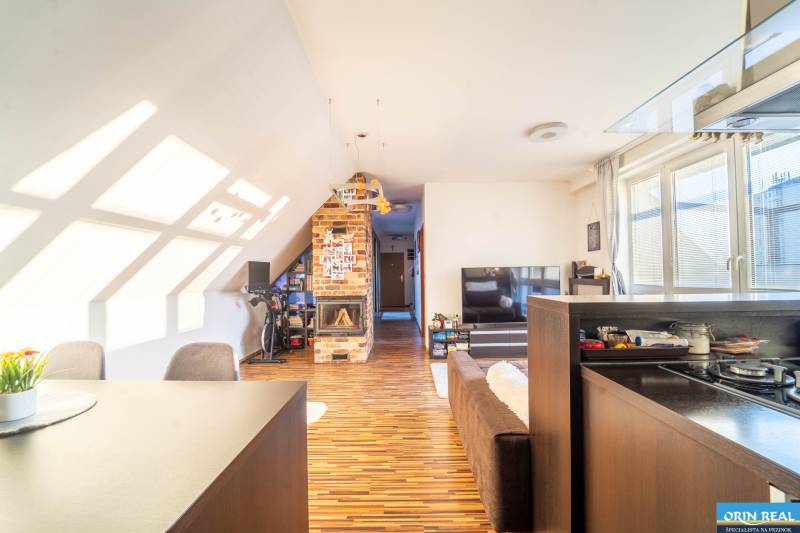 Living room in a 2-room apartment with a wooden decor floor and a brick fireplace.