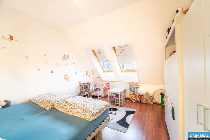 A children's room in a two-room apartment with skylights, furniture, and toys.