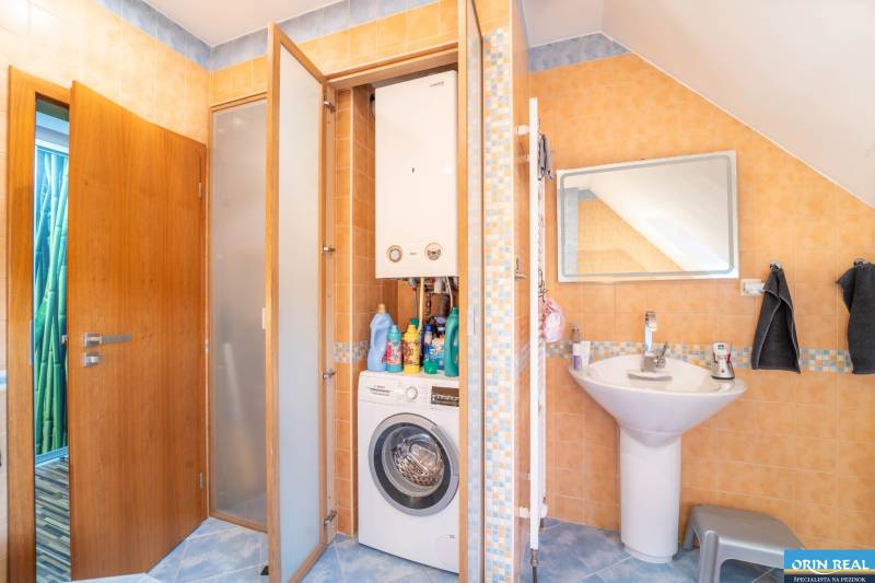 Bathroom in a 2-room apartment with a washing machine, gas boiler, and sink.