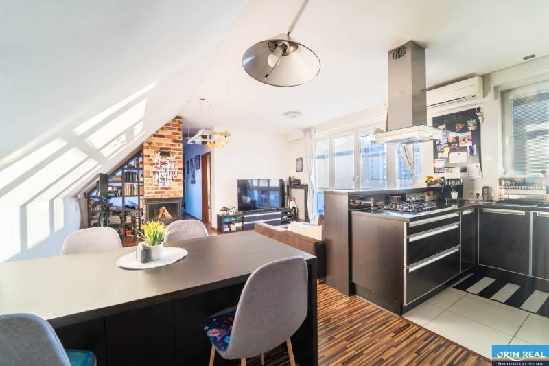 A kitchen with a TV, fireplace, and wooden decor flooring in a 2-room apartment.