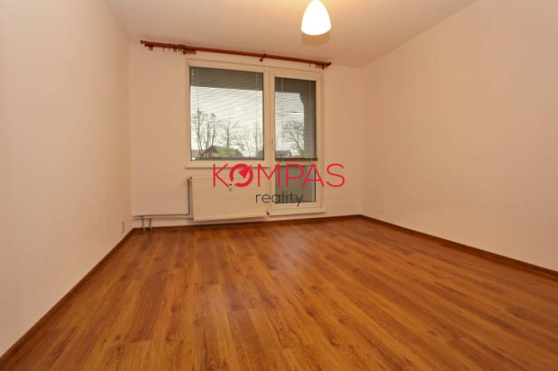 A room in a 3-room apartment with a wooden decor floor, the space is empty.