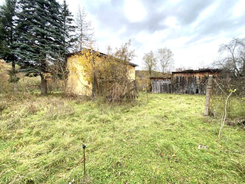 A family house in Rykynčice, surrounded by nature, next to wooden structures and trees.