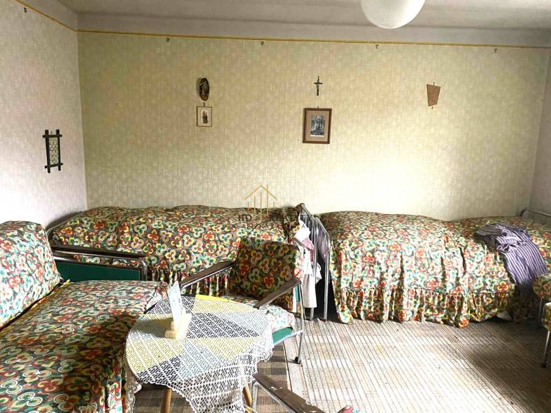 A room in a family house with three beds and a table, decorated with decor.