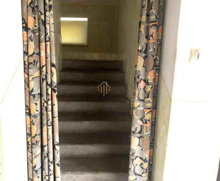 Concrete stairs in a family house, covered with a patterned curtain.