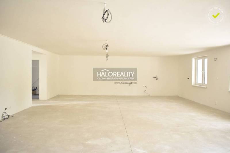 A spacious unfurnished room with windows in a family house.