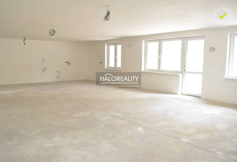 An empty interior of a family house with an unfinished floor and windows.