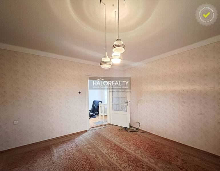 A room in a family house with carpet flooring and pendant lighting.