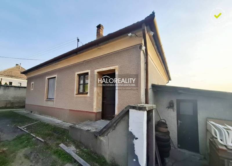 A family house in Dvory nad Žitavou with a plastered facade, exterior stairs, and a courtyard.