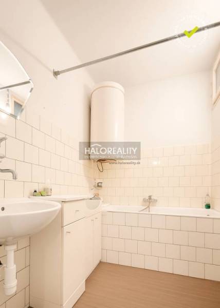 A bathroom in a family house with a bathtub, a sink, and a floor with a wooden design.