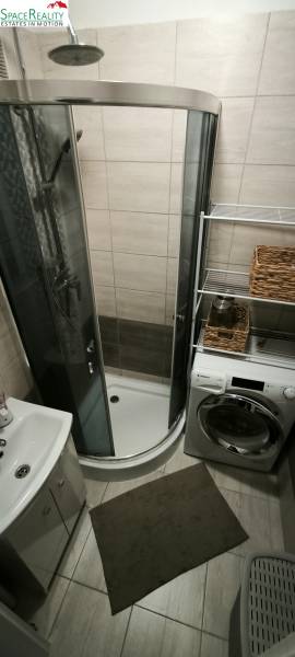 Bathroom in a 3-room apartment with a shower, sink, and washing machine.