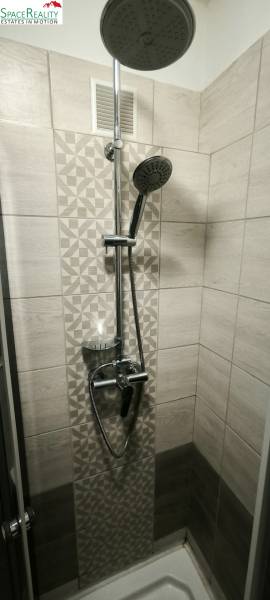 A shower corner with modern tiles in a 3-room apartment.