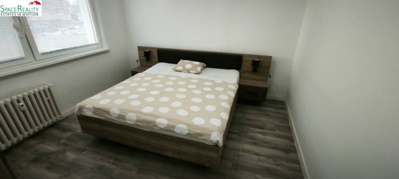 A bedroom with a double bed and a wooden decor floor in a 3-room apartment.