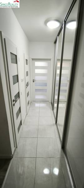 A hallway with mirrored closets and white doors in a 3-room apartment.