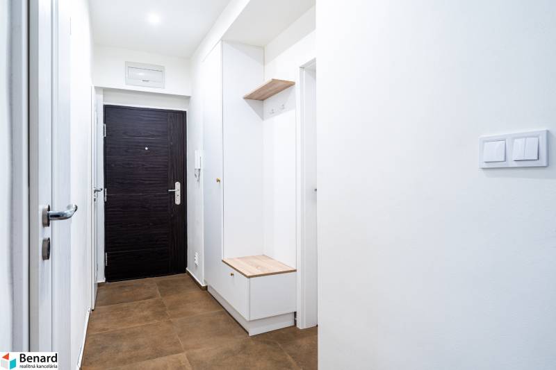 Bright hallway in a 3-room apartment with brown tiles and storage space.