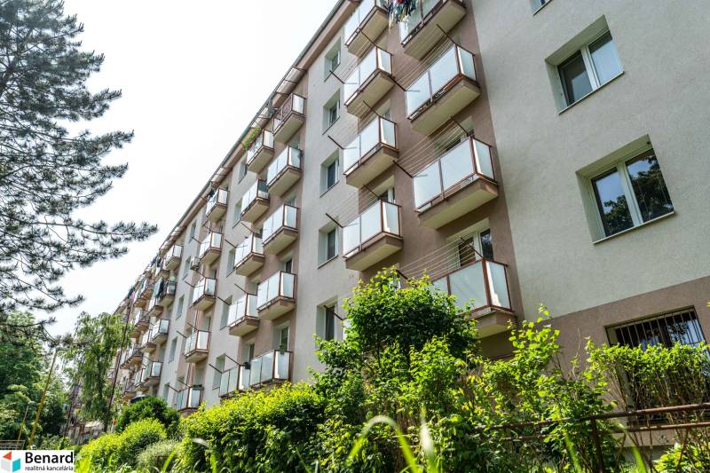 An apartment building with balconies surrounded by greenery on Vodárenská Street in the Košice-Sever district.