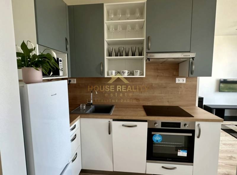 A kitchen in a 2-room apartment with a white refrigerator and wooden decor.