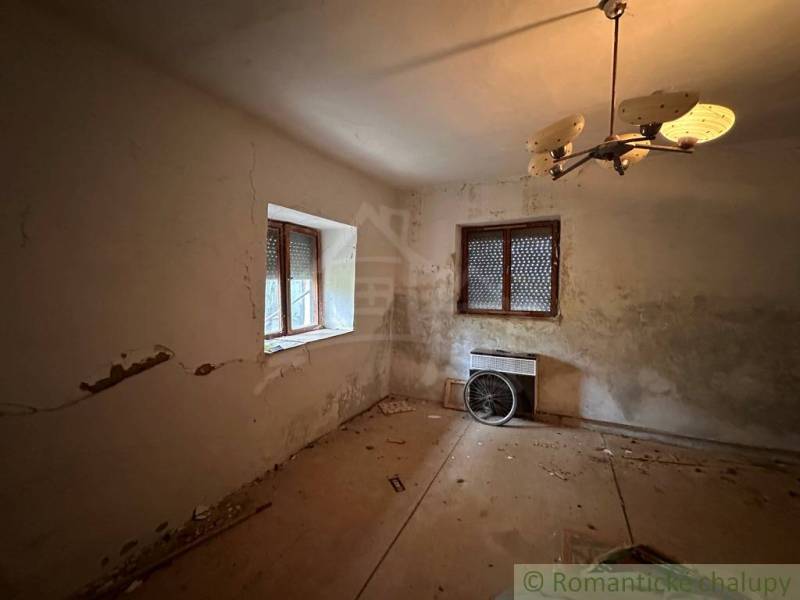 A room in a family house with a panel floor, old lighting, and a radiator.