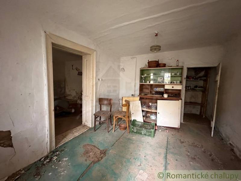 An abandoned room in a family house with furniture and a worn-out floor.