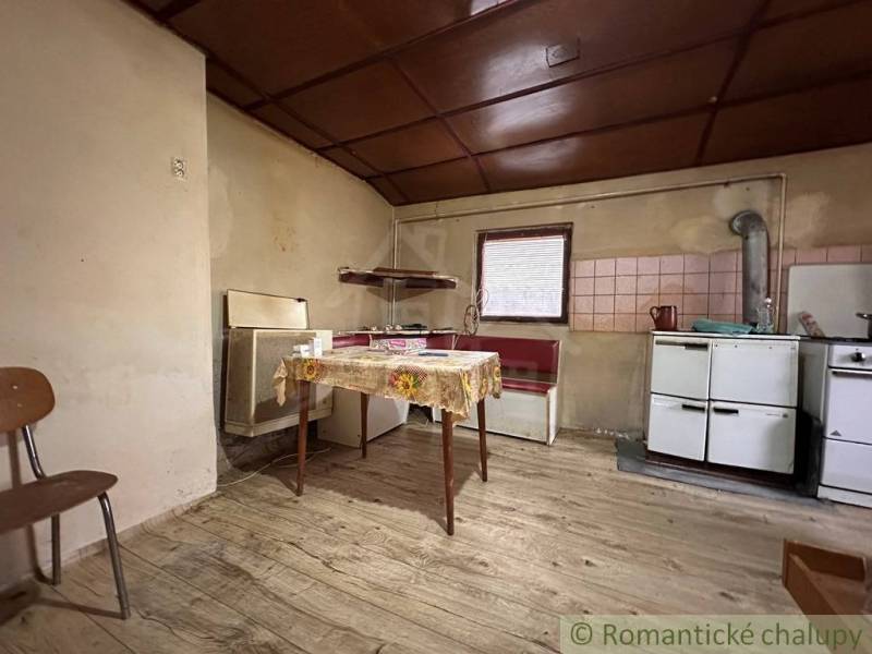 A kitchen in a family house with a wooden decor floor and simple furnishings.