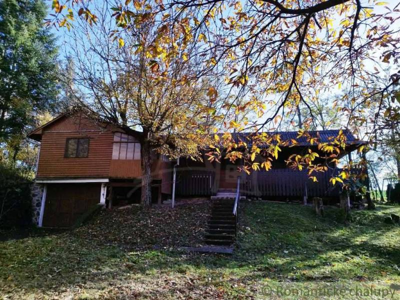 A cottage in Dudince surrounded by autumn leaves and trees.