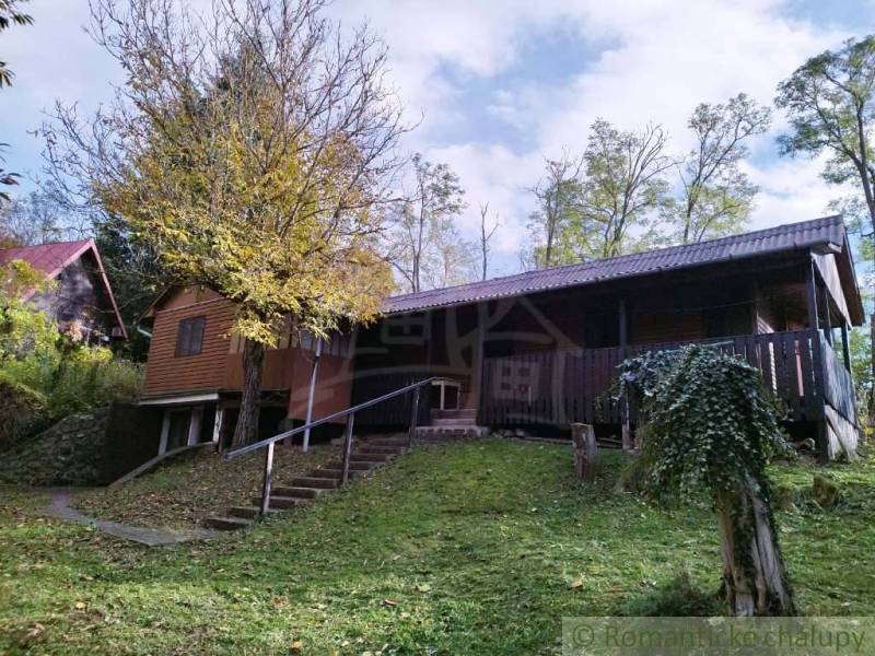 A cottage in Dudince surrounded by nature with a terrace and trees in the yard.