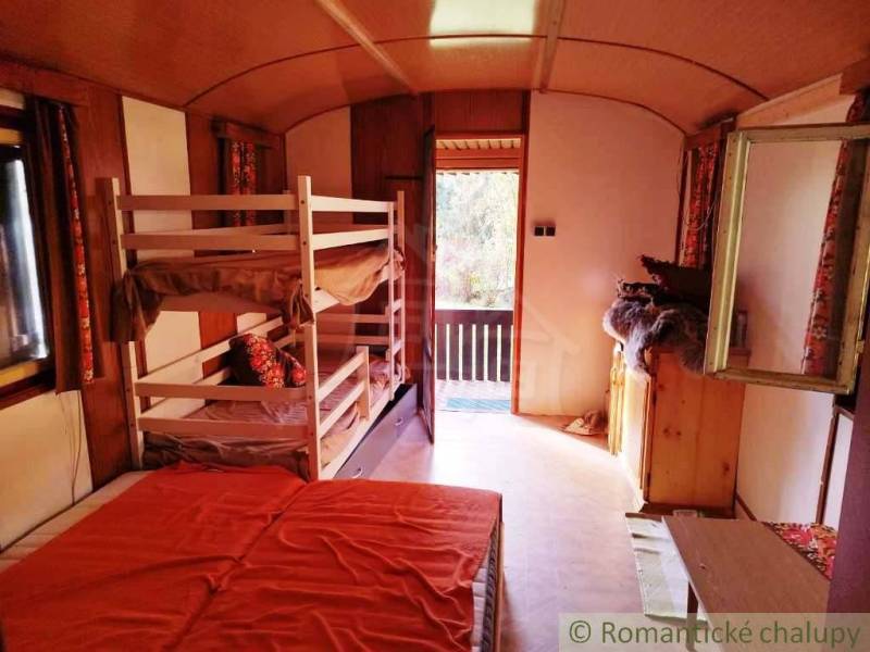 Interior of a cabin with four beds and a bright view of the terrace.