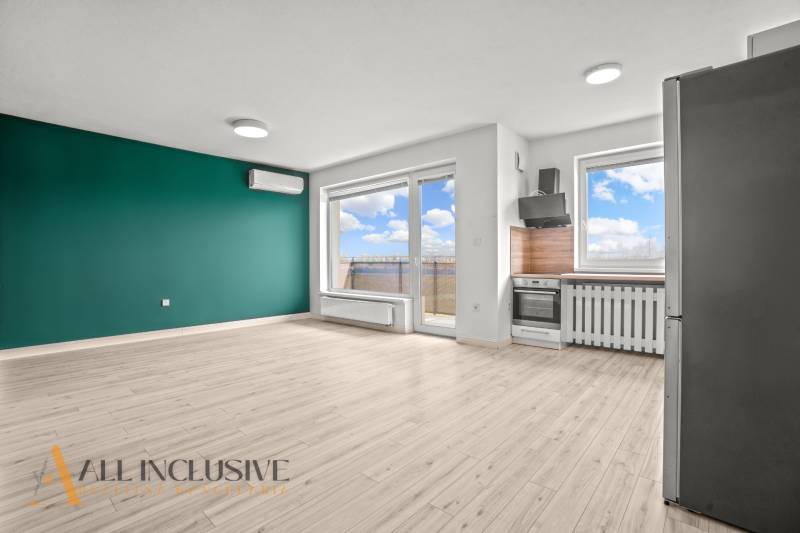 Living room with a kitchenette in a 2-room apartment and a floor with a wooden decor.