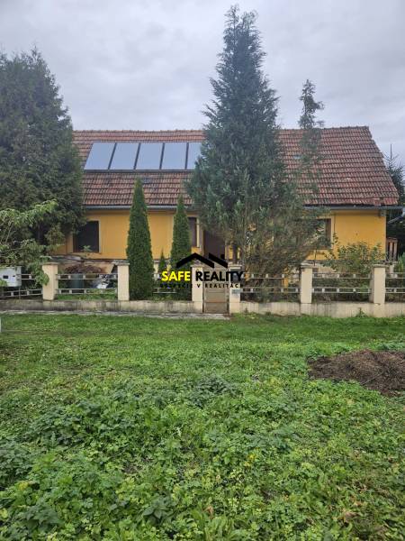 A family house on Sapietová Street in Gbeľany, surrounded by greenery with large windows on the roof.