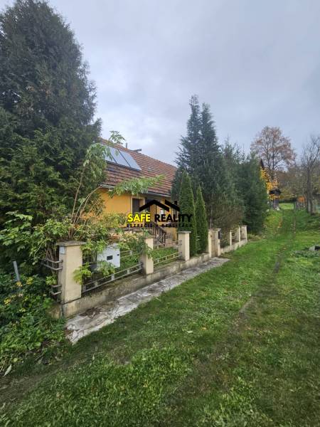 A family house on Sapietova Street in Gbeľany surrounded by greenery and a fence.