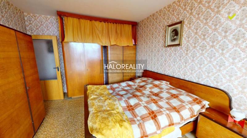 A bedroom in a 3-room apartment with decorative wallpaper and wooden furniture.