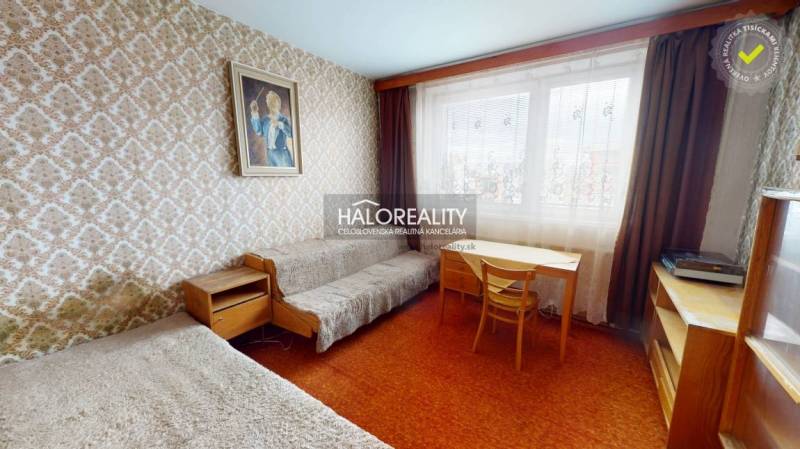 A room in a 3-room apartment with a carpet, furniture, and a painting on the wall.