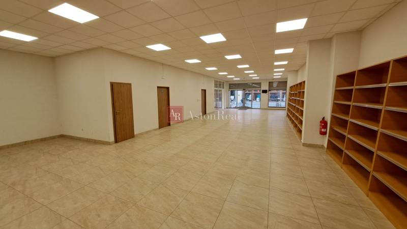 Commercial space with tiles, shelves, and glass doors for entry.