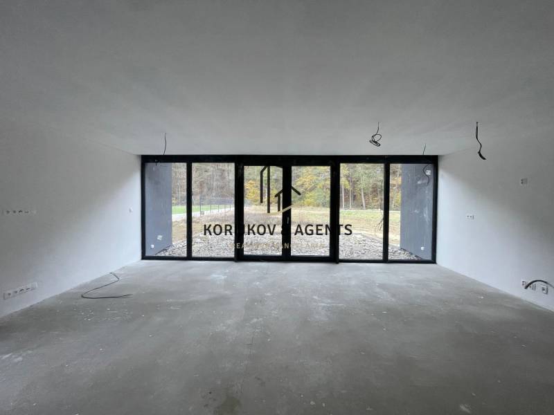 Spacious room with large windows in a family house, view of the garden.