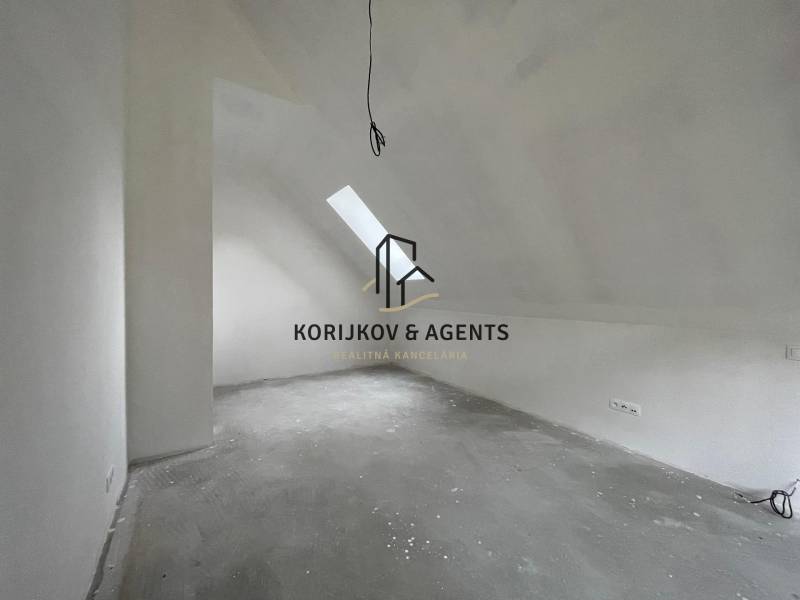 Attic room in a family house with a skylight and electrical outlets.