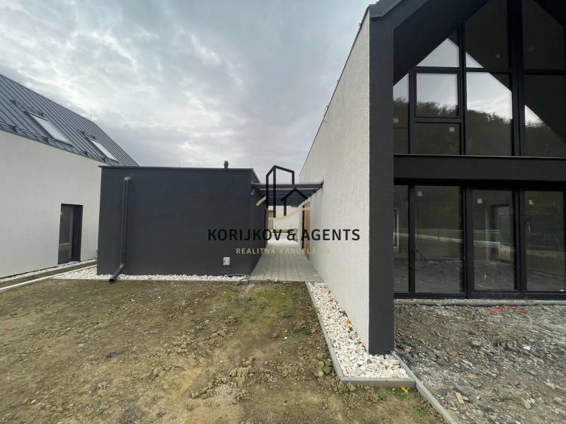 Family house on Pod Drieňovou in Kamenica nad Cirochou with glass surfaces and gravel paths.